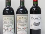 three bottles of red wine are lined up on a table