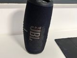 L'enceinte portable JBL Flip est posée sur une table à côté d'un ordinateur portable