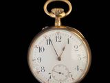 a close up of a pocket watch on a black background