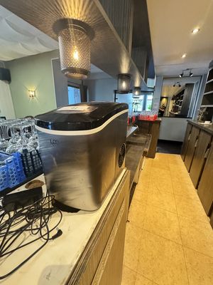 une photo d'une cuisine avec de nombreuses bouteilles d'eau posées sur le plan de travail