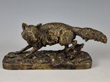 une image représentant une statue en bronze d'un renard posé sur un rocher