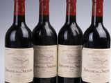 quatre bouteilles de vin sont alignées sur une surface blanche