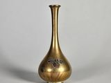 un vase ancien en laiton orné d'un motif floral sur le fond