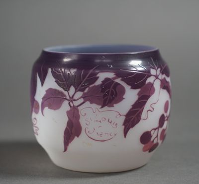 a purple and white vase with leaves on it