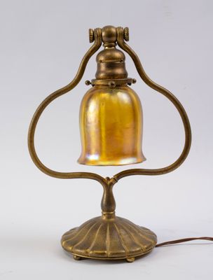 an antique brass table lamp with a bell on a stand