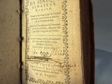 someone is holding an old book with writing on it in their hand