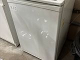 a white refrigerator sitting next to a black trash can