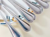 a lot of spoons and forks on a plate on a table