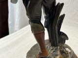 statue en bronze représentant un homme avec un chien, posée sur un socle