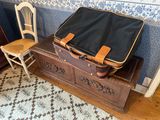 a suitcase sitting on top of a chest in a room