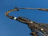 a close up of a necklace on a blue background