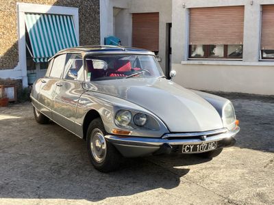 une voiture de couleur argentée garée devant un bâtiment