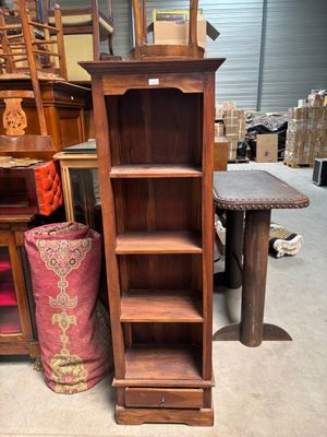 a tall wooden shelf with a mirror on top of it