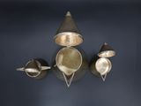 three cups and spoons on the wall next to each other