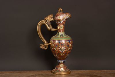 an image of a gold and green vase sitting on top of a wooden table