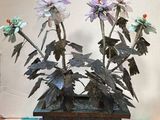 une jardinière en métal remplie de fleurs, posée sur un sol carrelé