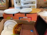 a cardboard box filled with assorted plates and utensils