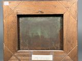 an old wooden picture frame with a plaque on it