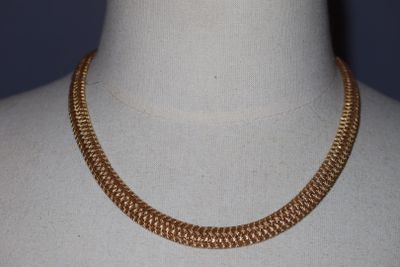 une photo d'un collier à chaîne en or porté par un mannequin