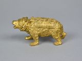 a gold bear figurine on a gray surface