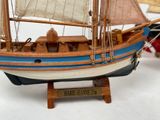 a wooden model of a boat with sails on display
