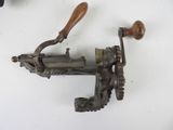 a metal object with a wooden handle on a white surface