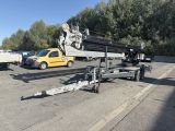une grue qui se trouve sur une remorque dans le parking