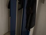 un casier bleu sur lequel est accroché un manteau, dans une pièce