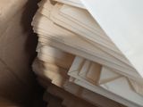 a pile of white envelopes sitting on top of a brown paper bag