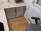 a desk with a computer monitor and a printer on it