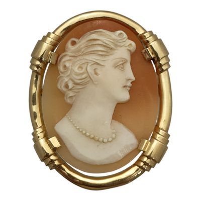 une image représentant le profil d'une femme sur une broche en or
