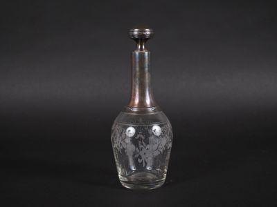 une vieille bouteille en verre munie d'un bouchon en métal, posée sur une surface noire