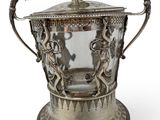 an antique silver plated ice bucket with handles on a stand