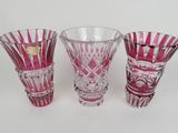 three pink glass vases sitting next to each other on a white surface