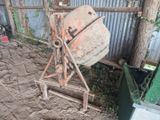 une bétonnière qui est posée par terre