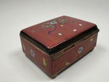 a red box with flowers on it sitting on a table