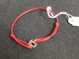 a red string bracelet with a star charm on it