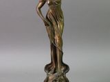 bronze statue of a woman holding a flower on a wooden base