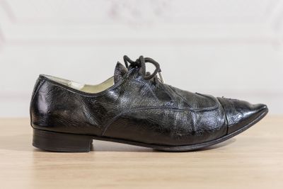 black leather shoes with laces on a wooden surface