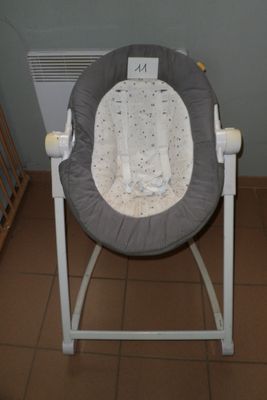 une photo d'une chaise berçante pour bébé dans une pièce