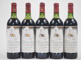 quatre bouteilles de vin rouge sont alignées sur une surface blanche