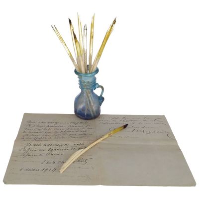un vase bleu rempli de crayons posé sur une feuille de papier