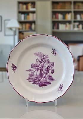 une assiette ornée d'un motif violet, posée sur une table