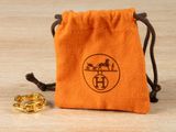 an orange bag with a gold ring on top of a wooden table