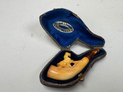 une petite pipe en bois dans un étui posé sur une table