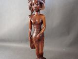 statue en bois représentant une femme tenant un panier, posée sur un socle