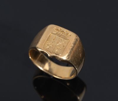 a close up of a gold ring with a coat of arms on it