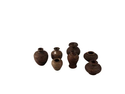 cinq petits vases posés les uns à côté des autres sur une surface blanche