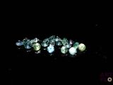 some very pretty green and blue gems on a black surface