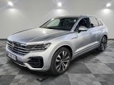 une Volkswagen Touareg argentée garée dans une grande pièce
